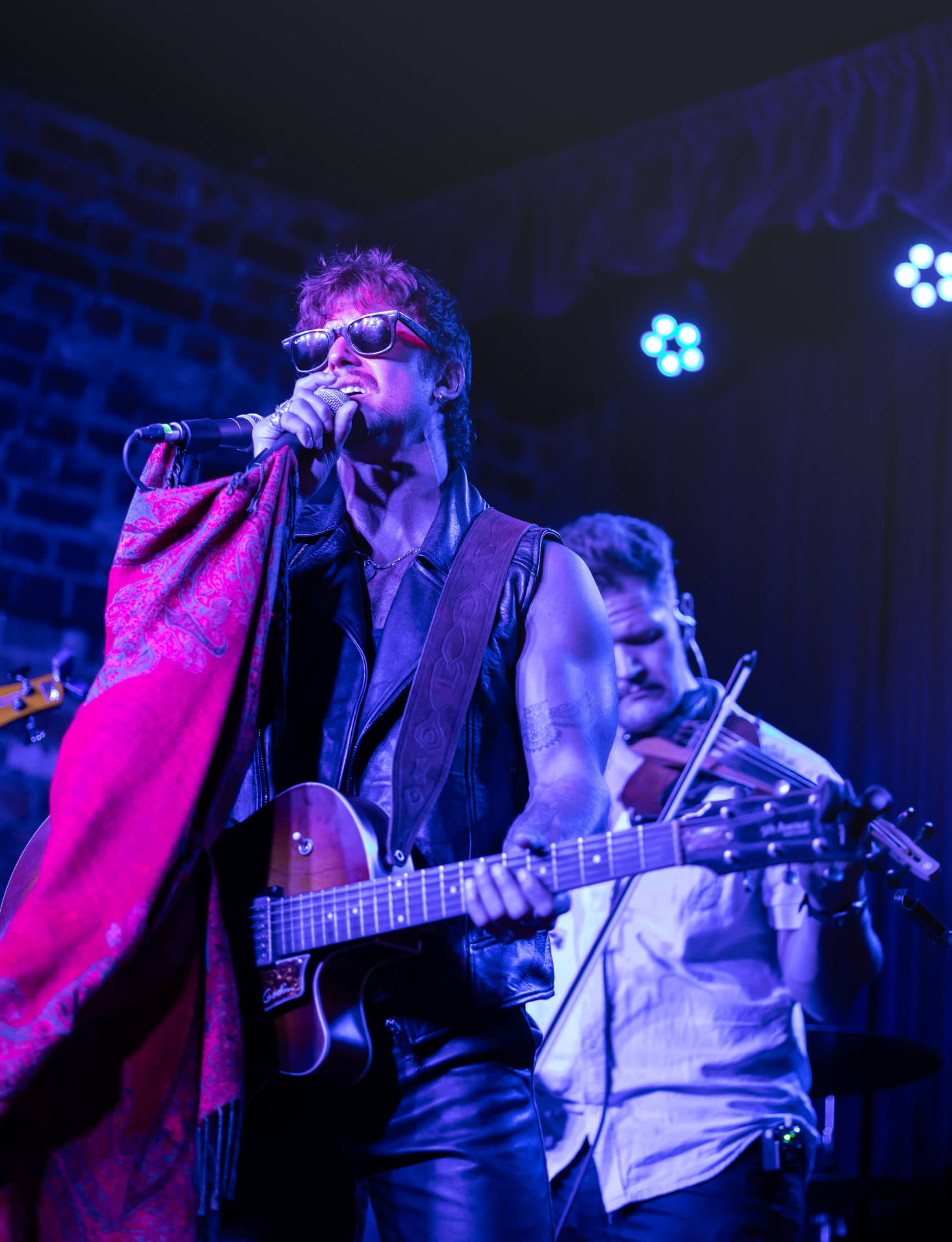 Freddy Gervasi performing on stage under purple lights
