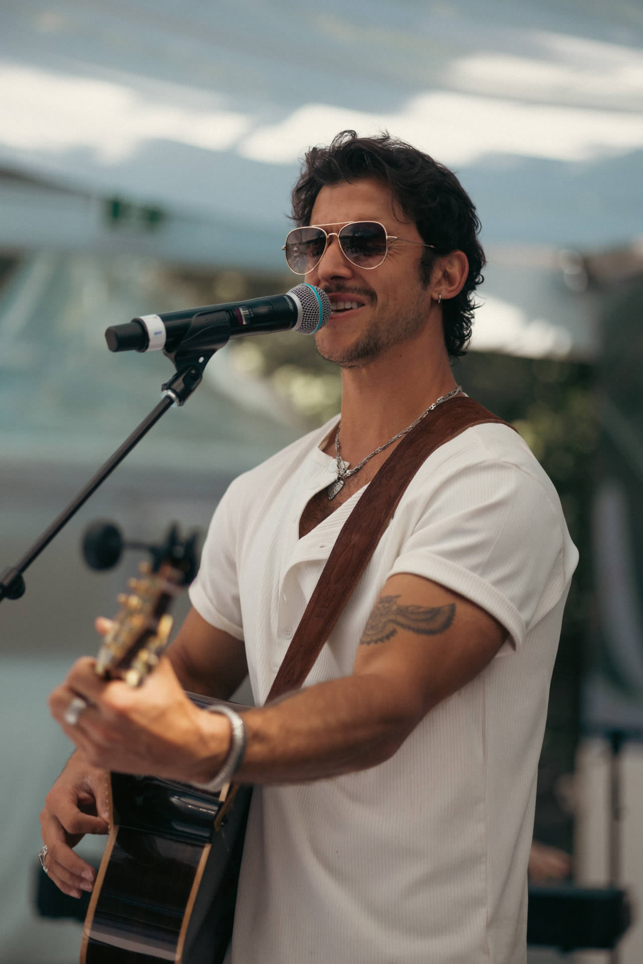 Freddy Gervasi singing with acoustic guitar outdoors